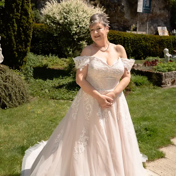 Braut im festlichen Brautkleid im Garten von SchlossFUN Seeburg