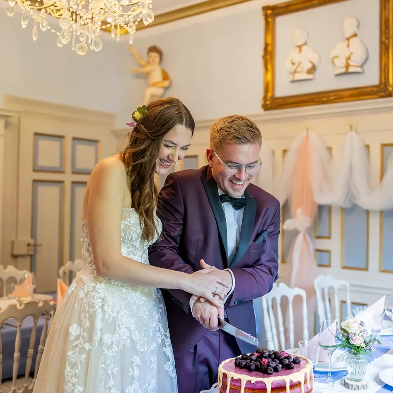 Brautpaar beim gemeinsamen Anschneiden der Hochzeitstorte im SchlossFUN Seeburg