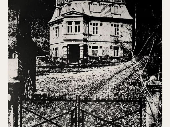 Historische Schwarz-Weiß-Fotografie des Schlössle Seeburg, aufgenommen vom Eingangsbereich mit Zufahrt und Garten.