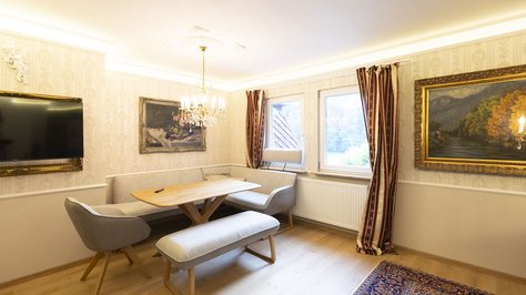 Gemütlicher Wohn- und Essbereich der Romantik-Suite im SchlossFUN in Seeburg bei Bad Urach mit Esstisch, Sofa, TV und stilvoller Einrichtung.