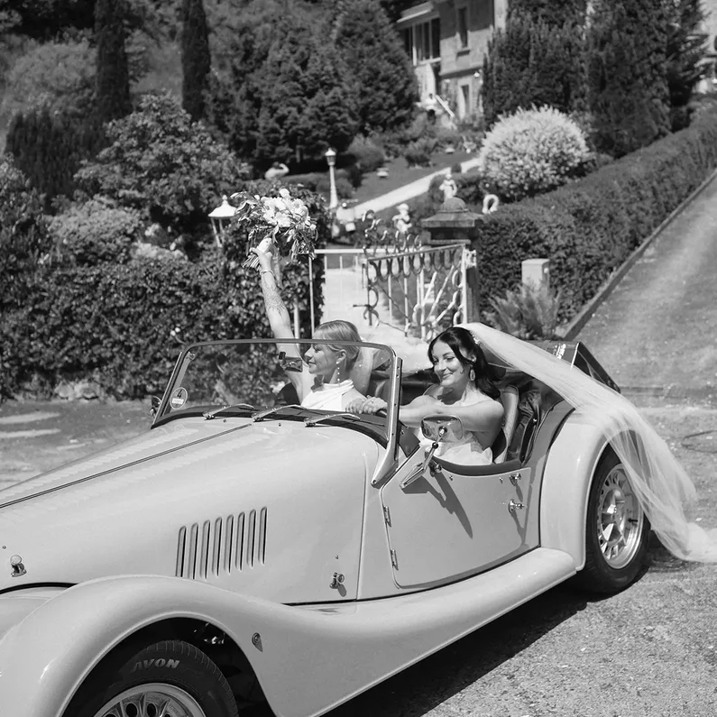 Weibliches Brautpaar im Morgan Roadster vor SchlossFUN Seeburg