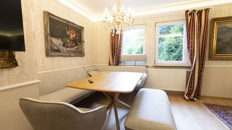 Stilvolles Esszimmer der Romantik-Suite im SchlossFUN in Seeburg bei Bad Urach mit Esstisch, Kronleuchter und Blick ins Grüne.