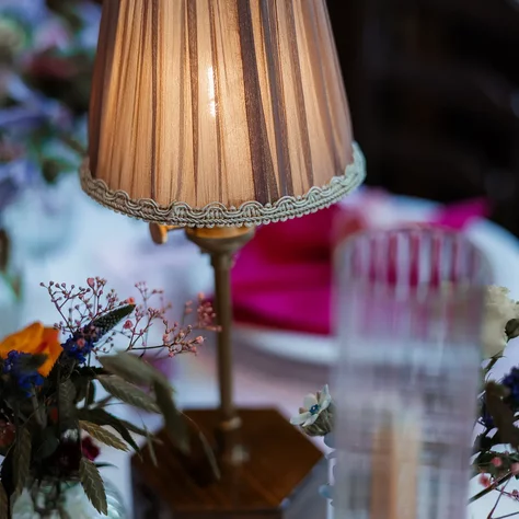 Detailaufnahme einer Tischleuchte mit Blumendekoration an der Hochzeitstafel im SchlossFUN