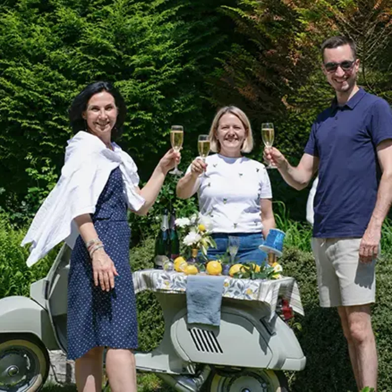 Gäste stoßen an der mobilen Vespa-Bar im Garten von SchlossFUN Seeburg an