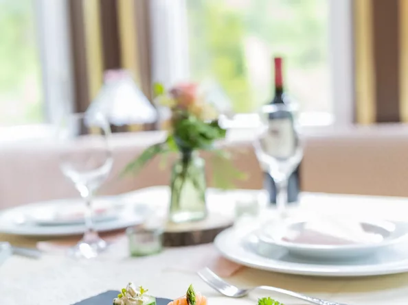 Festlich gedeckter Tisch mit Geschirr, Gläsern und Blumendekoration im SchlossFUN Seeburg