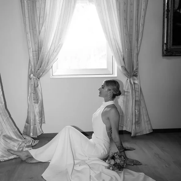 Braut im Hochzeitskleid am Fenster von SchlossFUN Seeburg