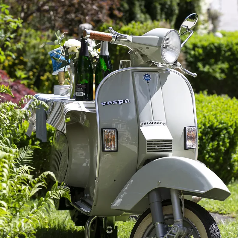 Vespa als mobile Bar mit Getränken und Gläsern im Garten von SchlossFUN Seeburg