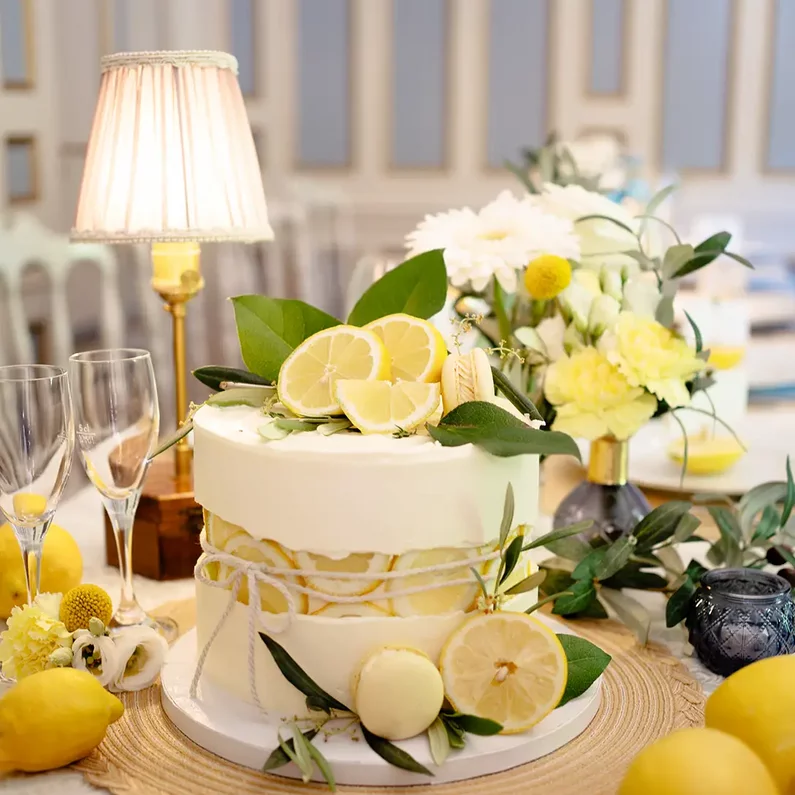 Hochzeitstorte mit Zitronen und Blumendekoration auf einer festlich gedeckten Tafel im SchlossFUN Seeburg