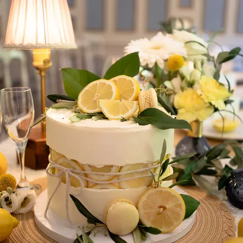 Hochzeitstorte mit Zitronen und weißen Blüten auf einer festlich gedeckten Tafel im SchlossFUN