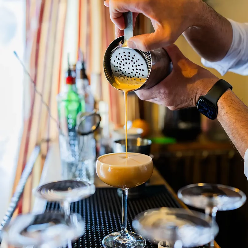 Barkeeper beim Einschenken eines frisch zubereiteten Cocktails im SchlossFUN Seeburg