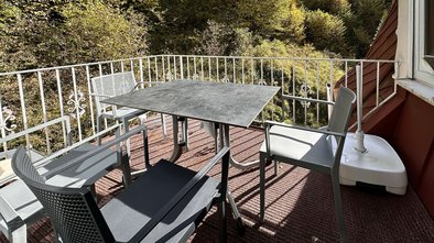 Sonnige Terrasse der Suite Nachtigall mit Sitzgruppe und Blick ins Grüne