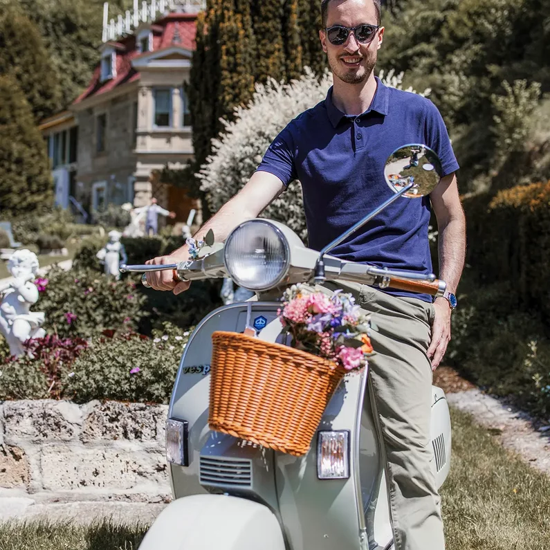 Besitzer von Dolce Vita Vespa mit seiner Vespa vor SchlossFUN Seeburg