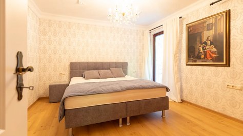 Helles Schlafzimmer der Romantik-Suite im SchlossFUN in Seeburg bei Bad Urach mit Doppelbett, Kronleuchter und stilvoller Einrichtung.Schlafzimmer der Romantik-Suite