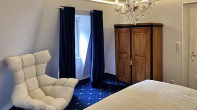 Suite Nachtigall mit komfortablem Designersessel, Kleiderschrank und warmem Lichtambiente